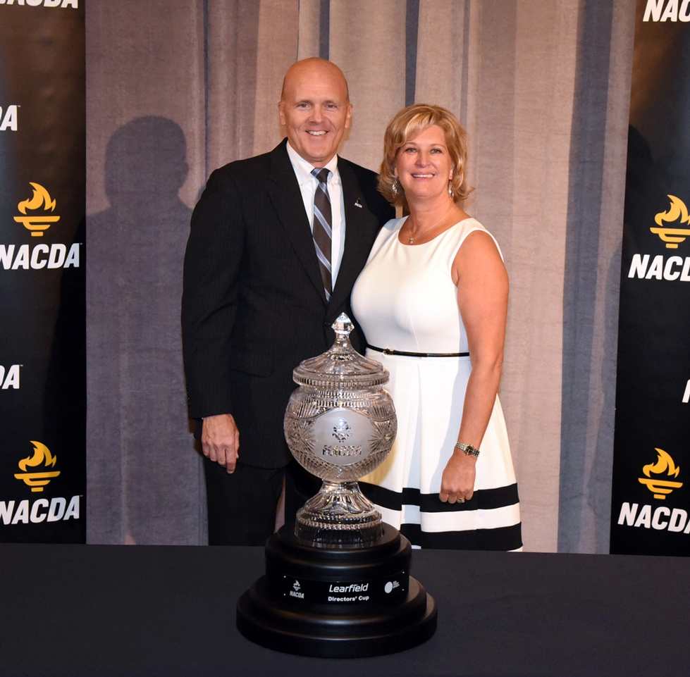 Tim and Terry Selgo stand behind the Learfield Sports Directors' Cup, presented to Grand Valley for having the top NCAA Division II athletic program.